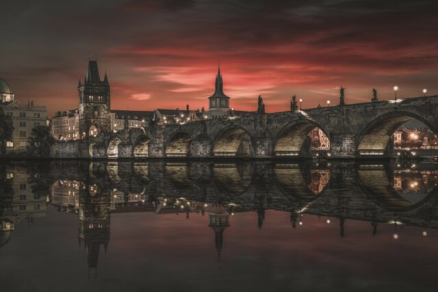 Night view of Prague, with a perfect reflection of the Charles Bridge in the river.