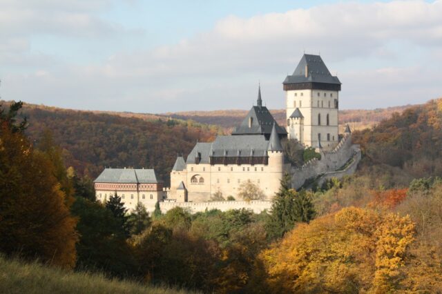 Autumn view of Karlštejn Castle among fall foliage.